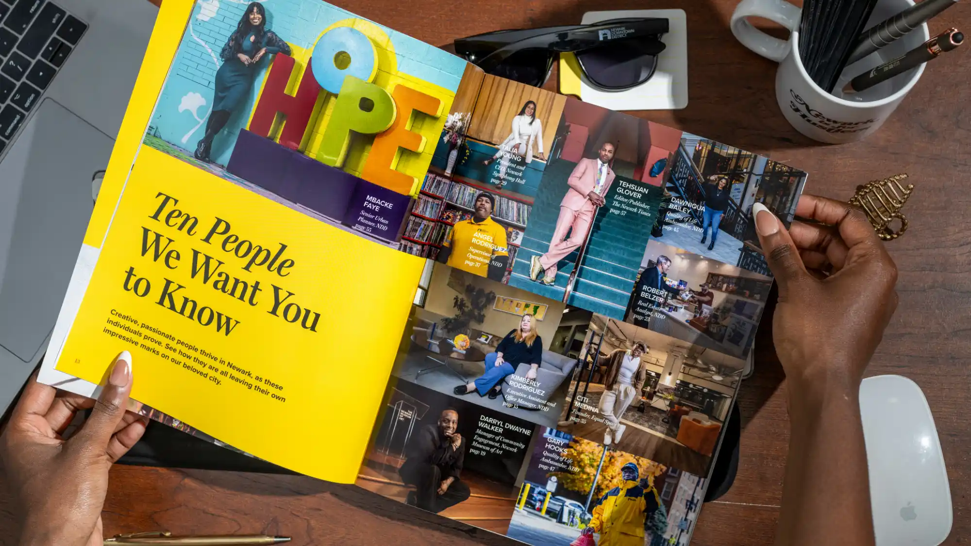 The cover story spread of the NDD community report on a desk with a person's hands holding it.