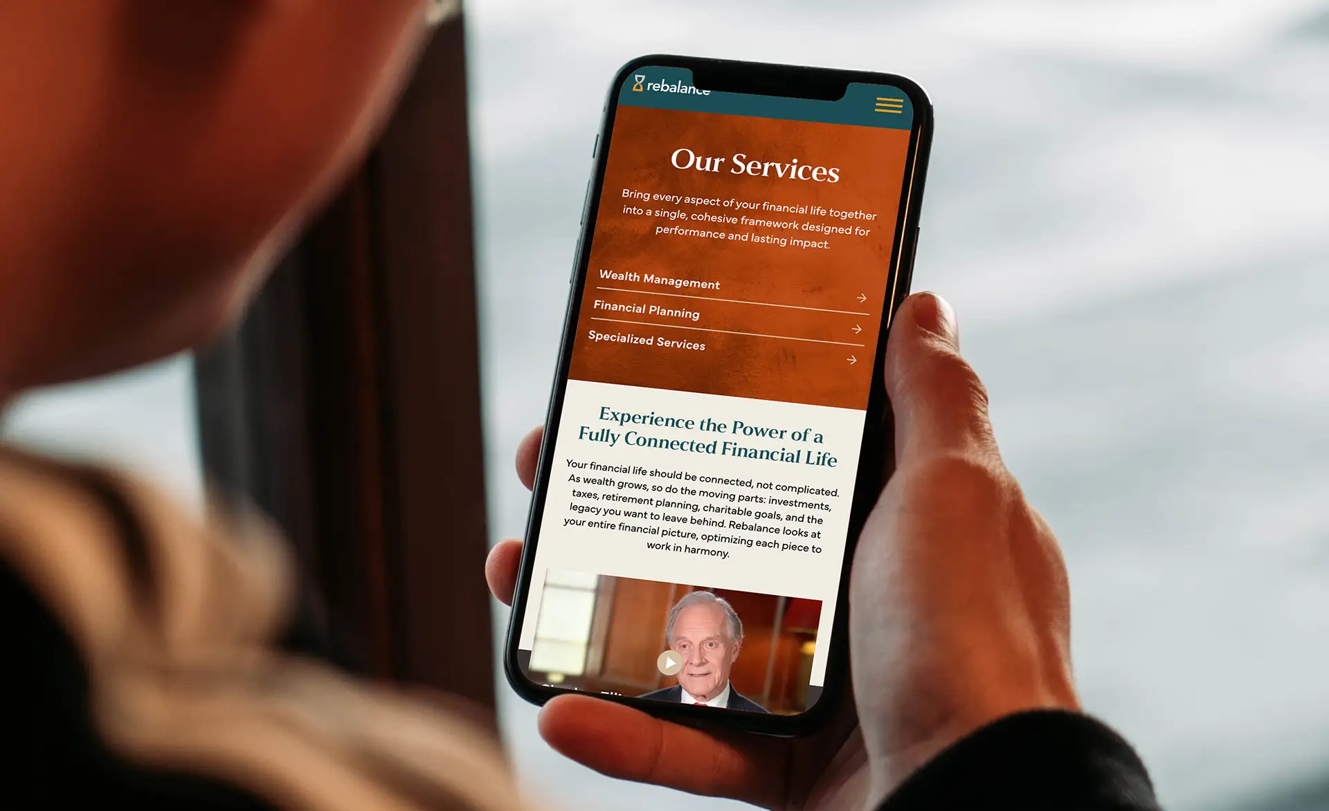 Person holding mobile device for Financial Services Firm website design
